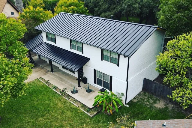 Aerial view of modern home with standing seam black metal roof