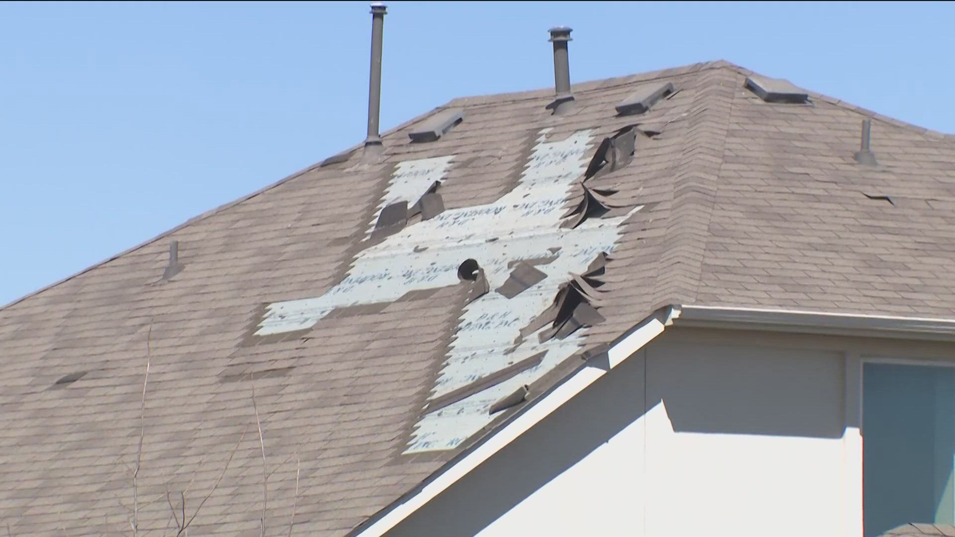 Close-up of exposed roof decking after hail and wind damage removed shingles