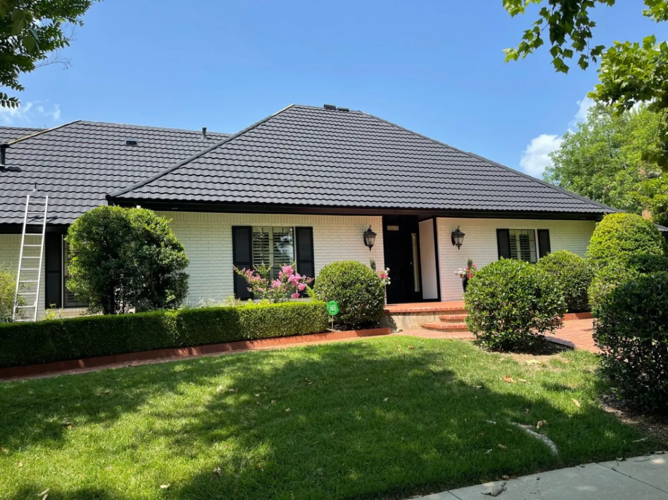 White brick ranch home with dark tile roof